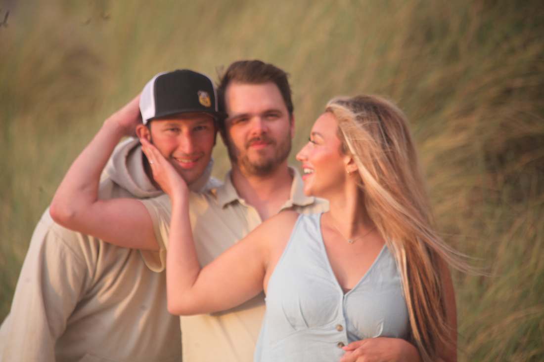 Jameson and Dawsyn laughing in tall grass at golden hour
